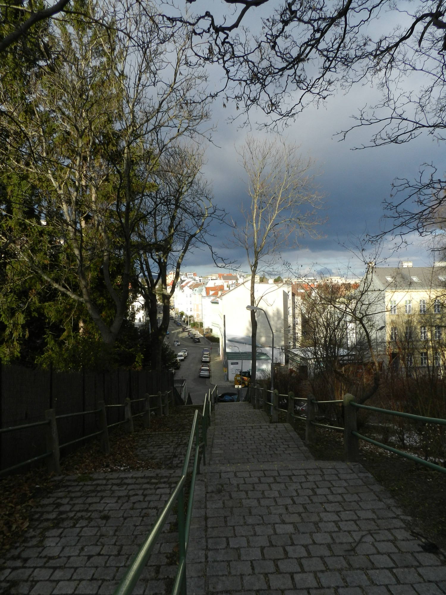 Ausblick auf dramatischen Himmel mit Sonne im Vordergrund von der Spitze der Treppe