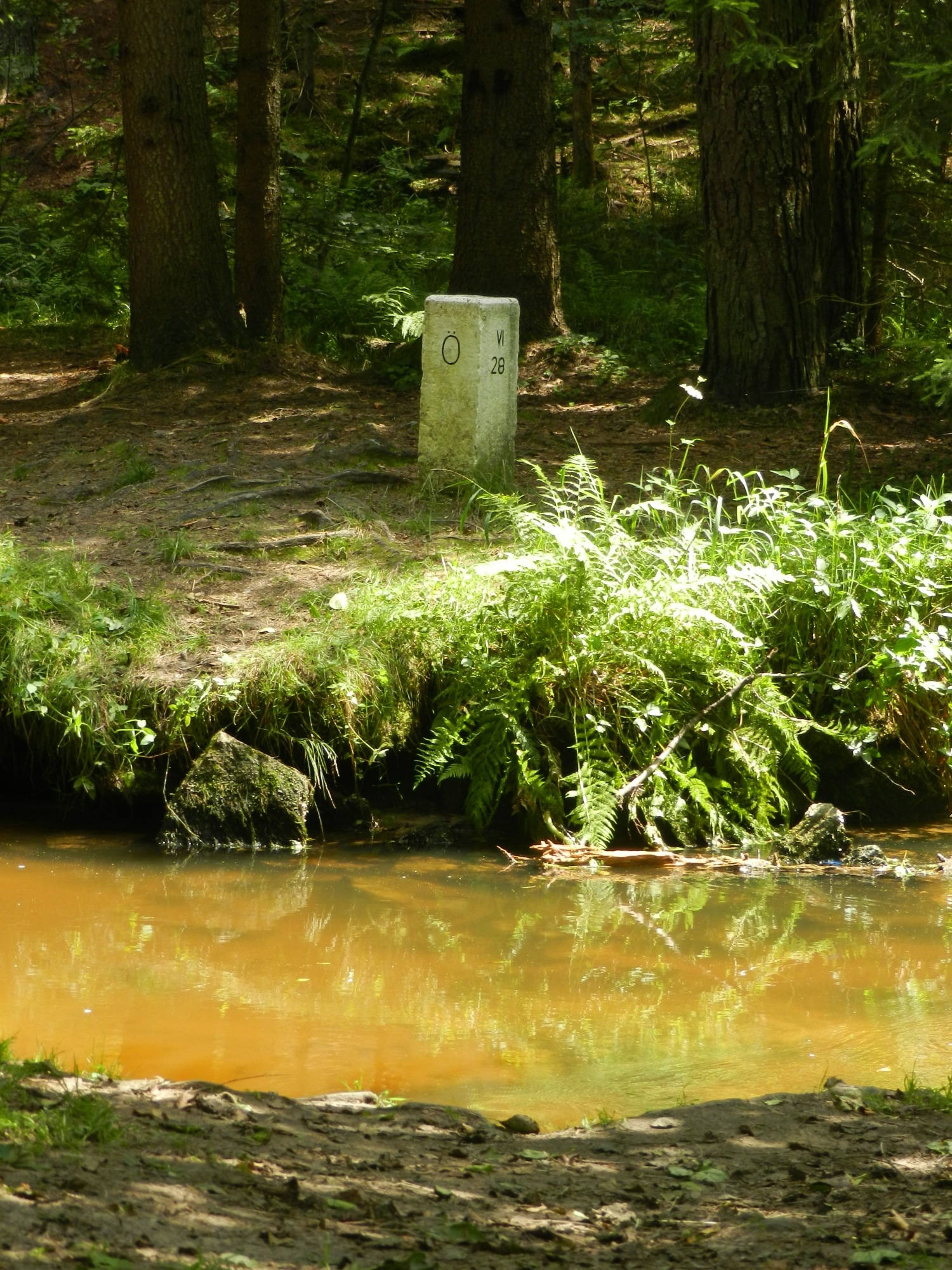 Grenzstein hinter dem Fluss