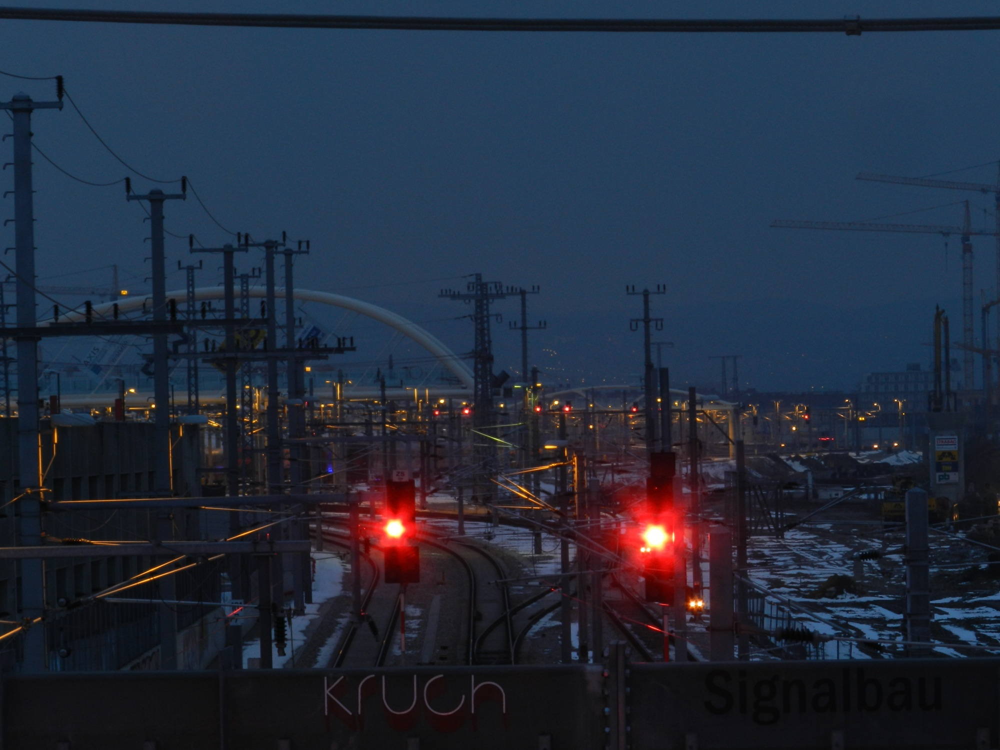 Ausblick in die Gegenrichtung, mit roten Ampeln über der Bahnstrecke