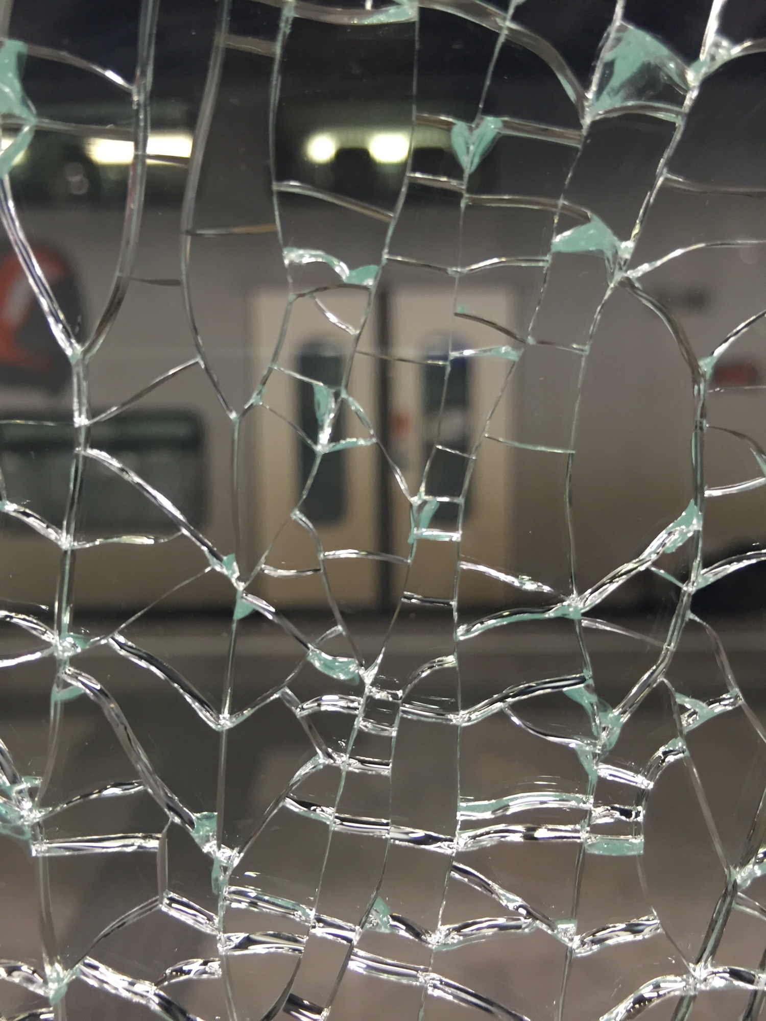 Blick auf den Regionalzug durch gesplittertes Glas am neuen Hauptbahnhof