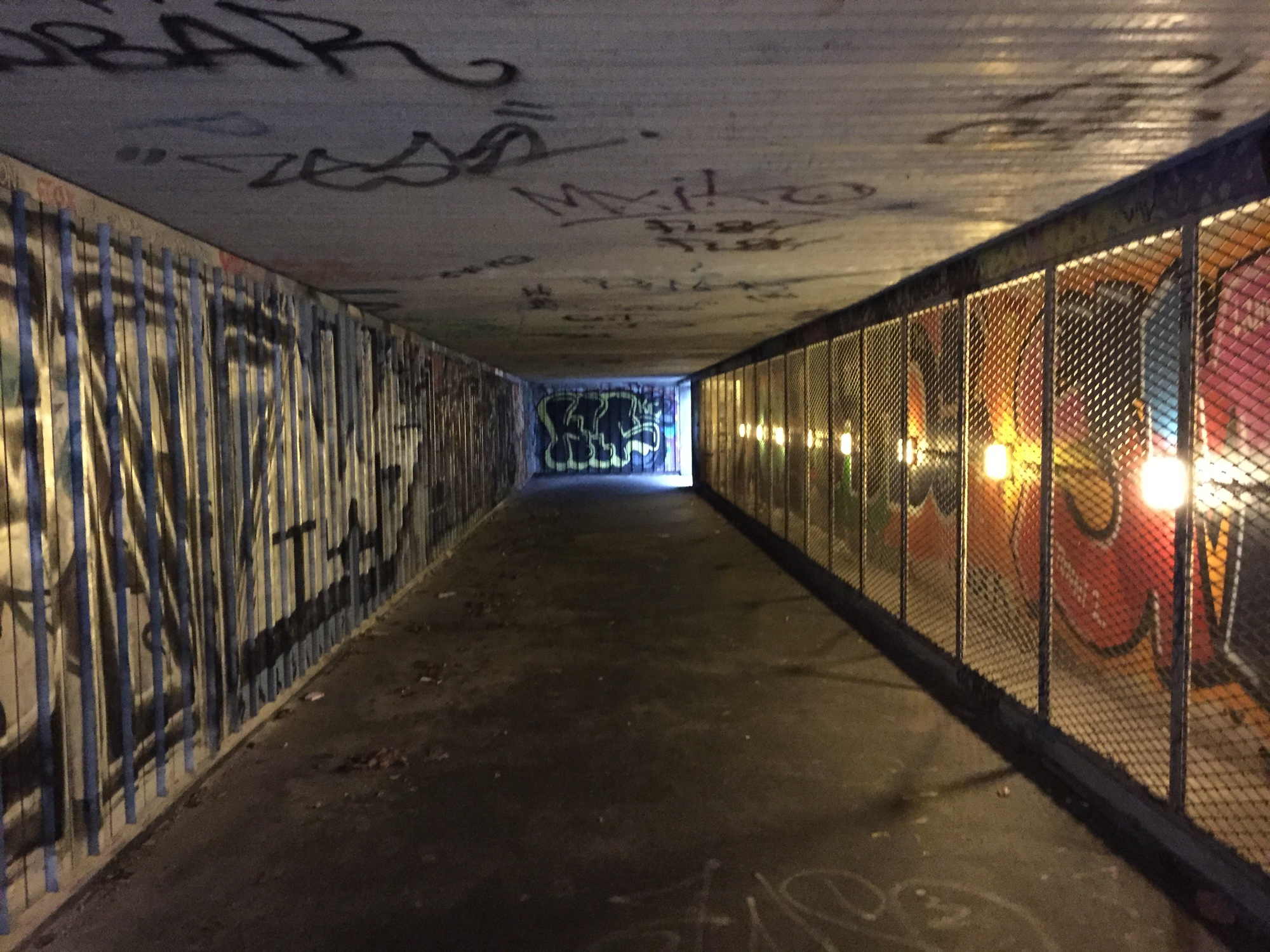 Unterführung für Fußgänger unter einer belebten Straße, besprayt, beleuchtet, trotzdem gruselig