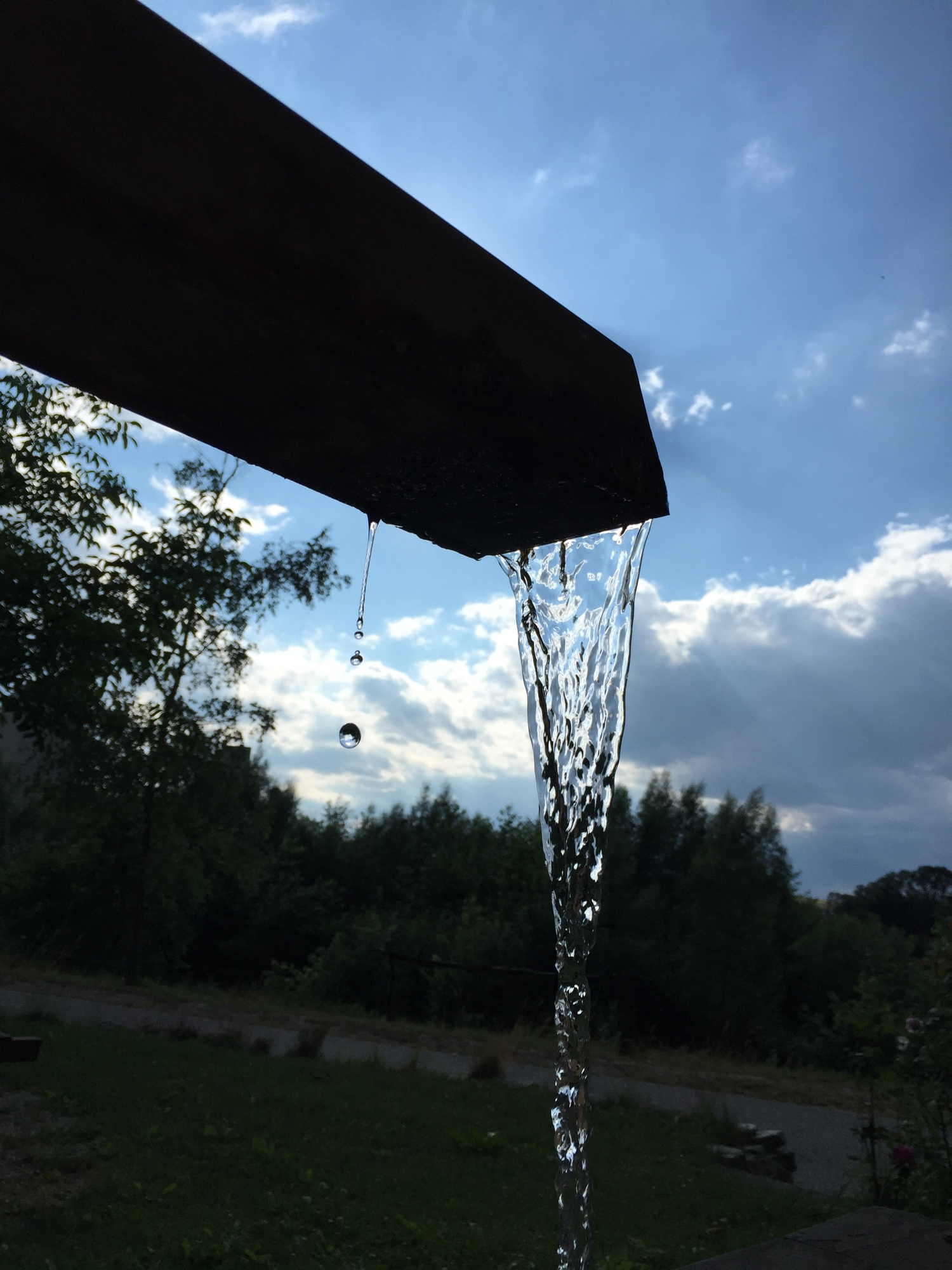 Brunnen im Gegenlicht mit eingefrorenem Wasserstrahl und Wassertropfen