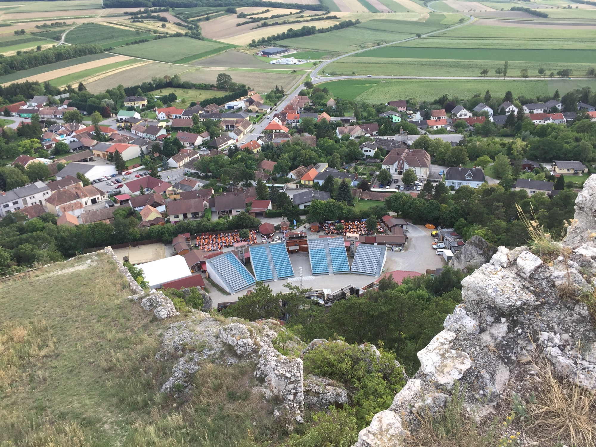Ausblick von oben auf das Festspielgelände mit Gastronomiebereich und Tribünen