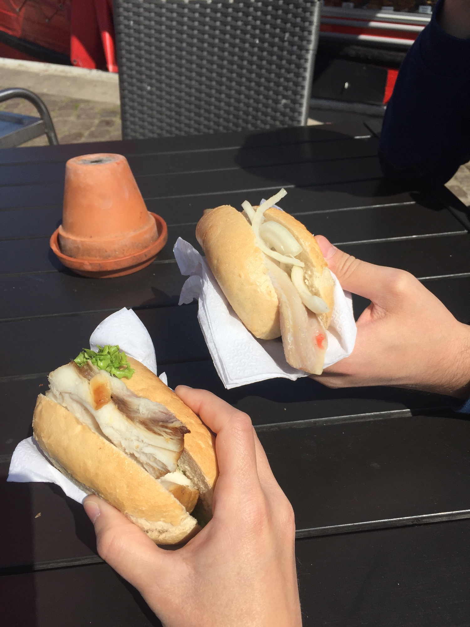Hände mit Fischbrötchen am Hafen beim Fischkutter Anja