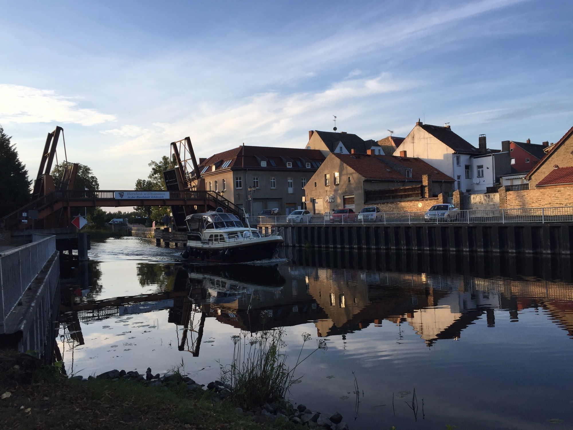 geöffnete Schleusenbrücke in Zehdenick, ein Boot fährt gerade aus der Schleuse heraus in Richtung Kamera