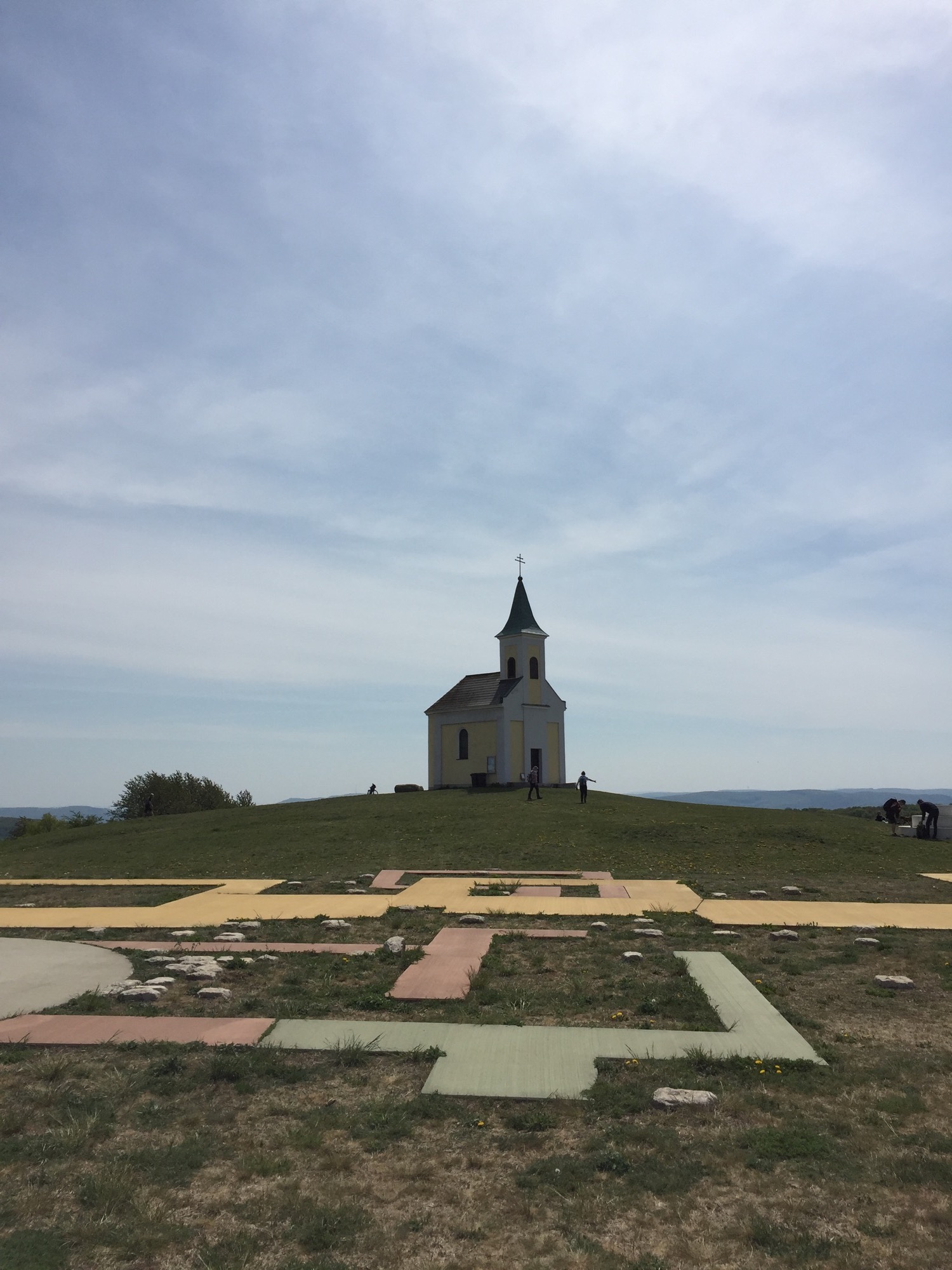 Kunstprojekt der Rekonstruktion von verschiedenen Bauphasen der Kirche auf dem Michelsberg im Vordergrund, dahinter die Kirche vor blauem Himmel