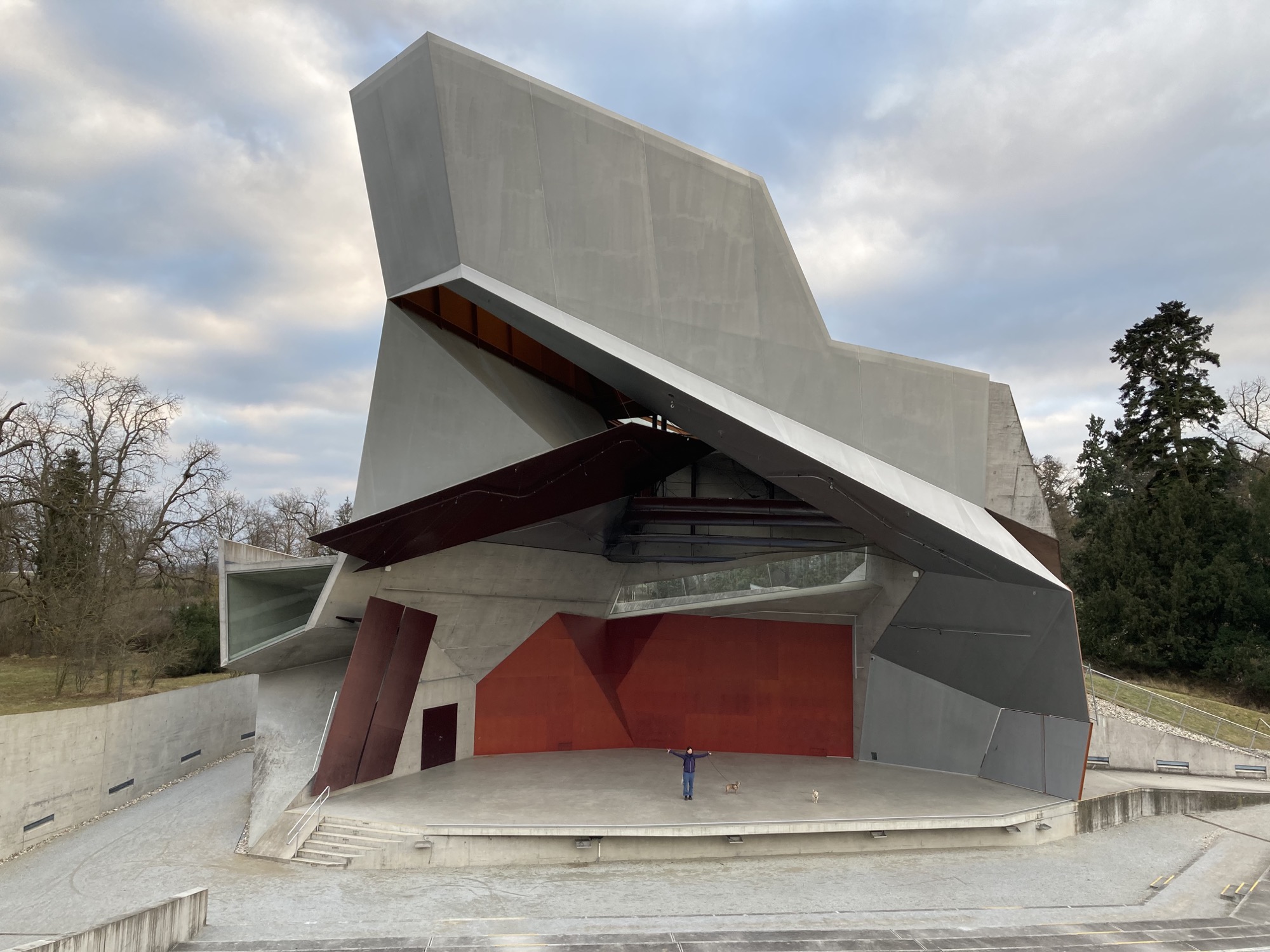 Blick von der Tribüne auf die Bühne des Wolkenturms, in der Mitte der Bühne eine Person mit ausgebreiteten Armen und zwei kleine Hunde