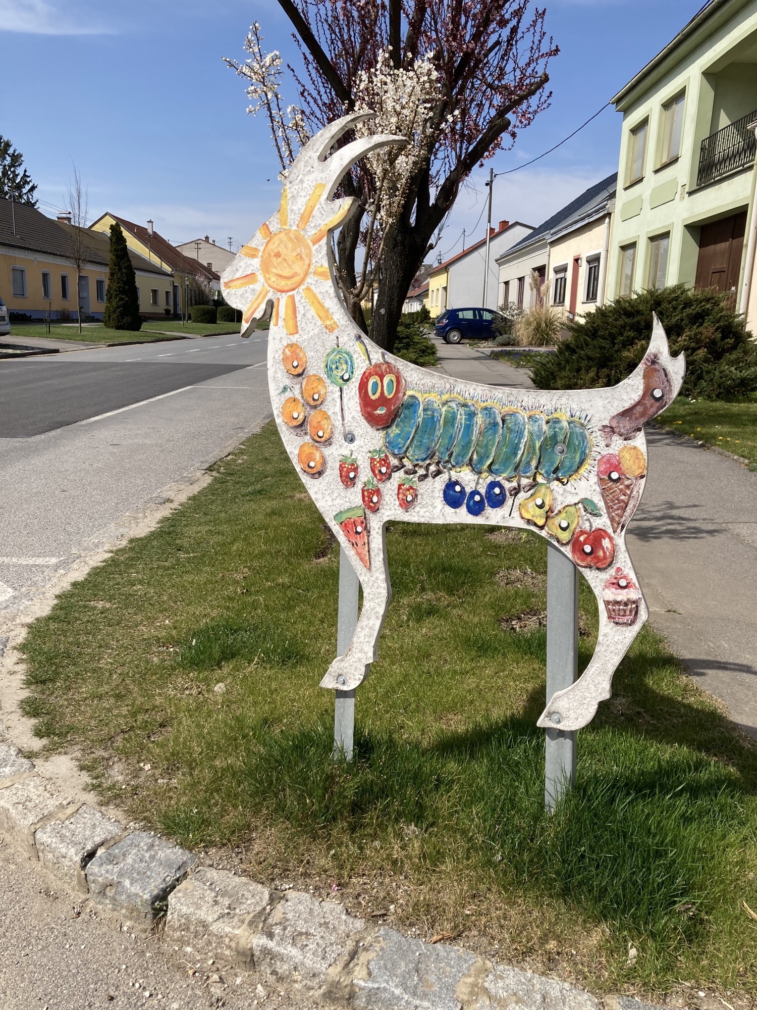 Darstellung eines Bocks bemalt mit der Figur der Raupe Nimmersatt und ihrer Nahrung