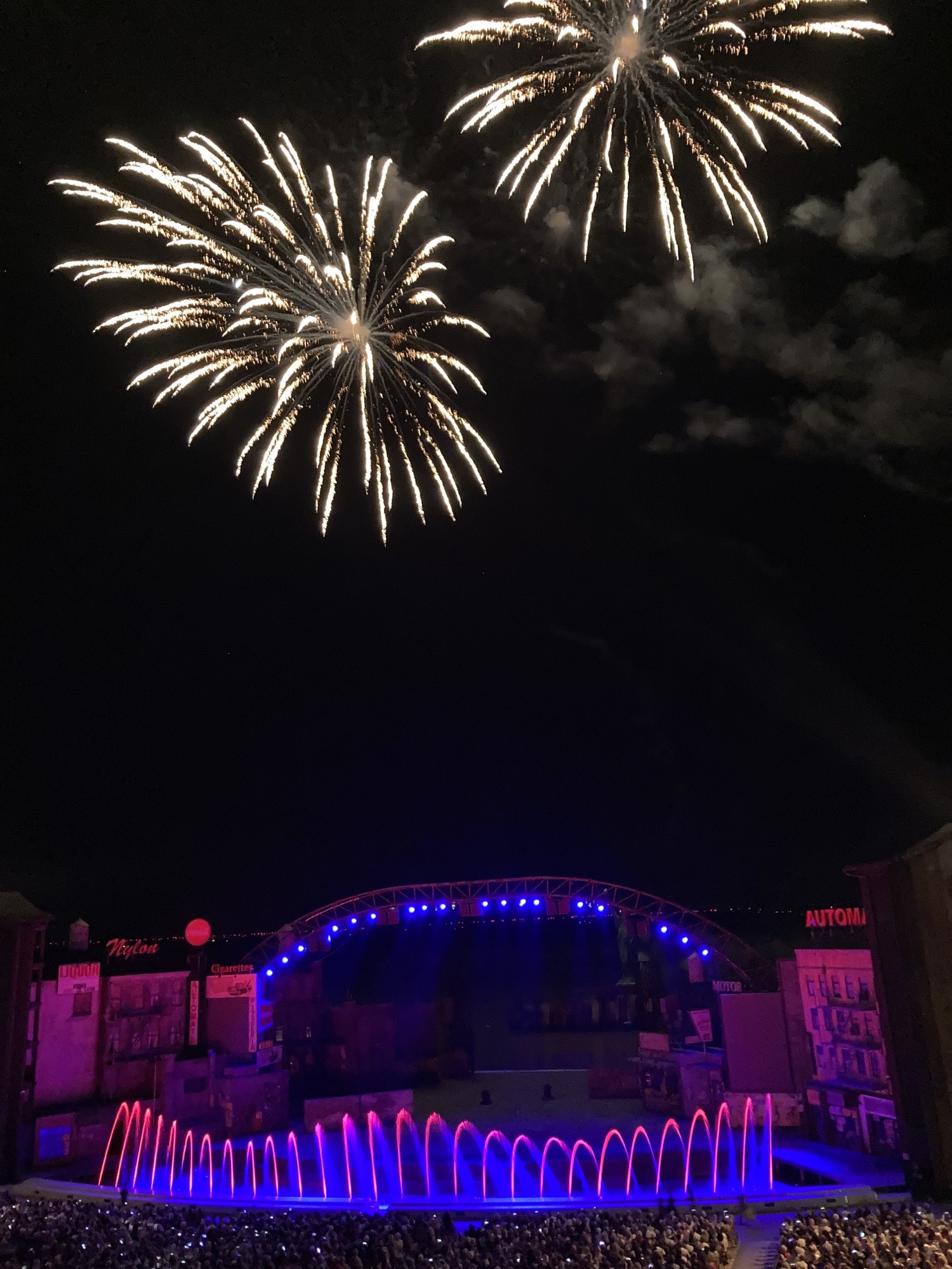 Seebühne Mörbisch mit Dekoration des Musicals „West Side Story“, Wasserspiel vor der Bühne und Feuerwerk im Hintergrund am Himmel