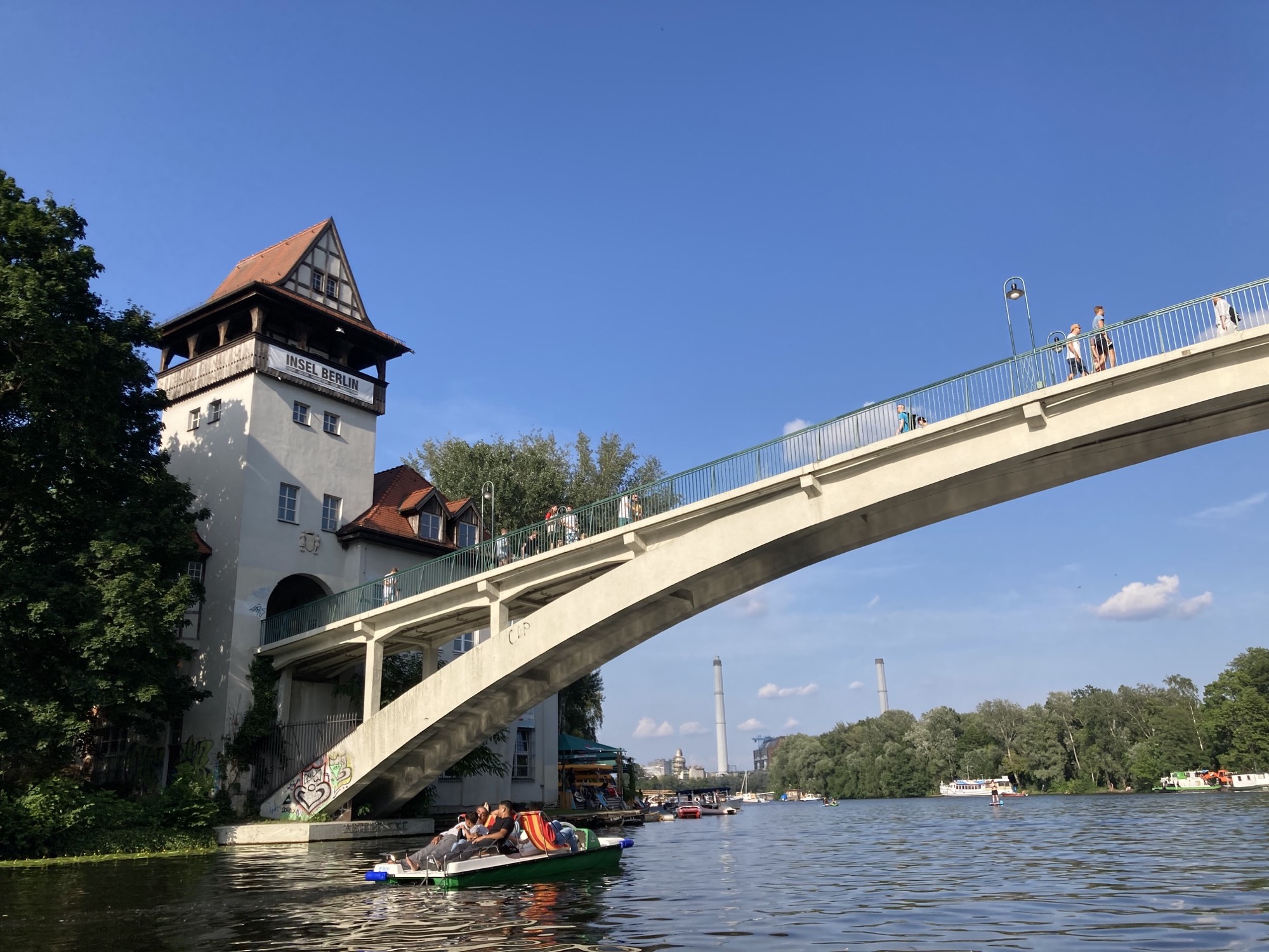 Blick vom Wasser aus auf die Brücke zur Insel der Jugend, links sind Tretboote unterwegs