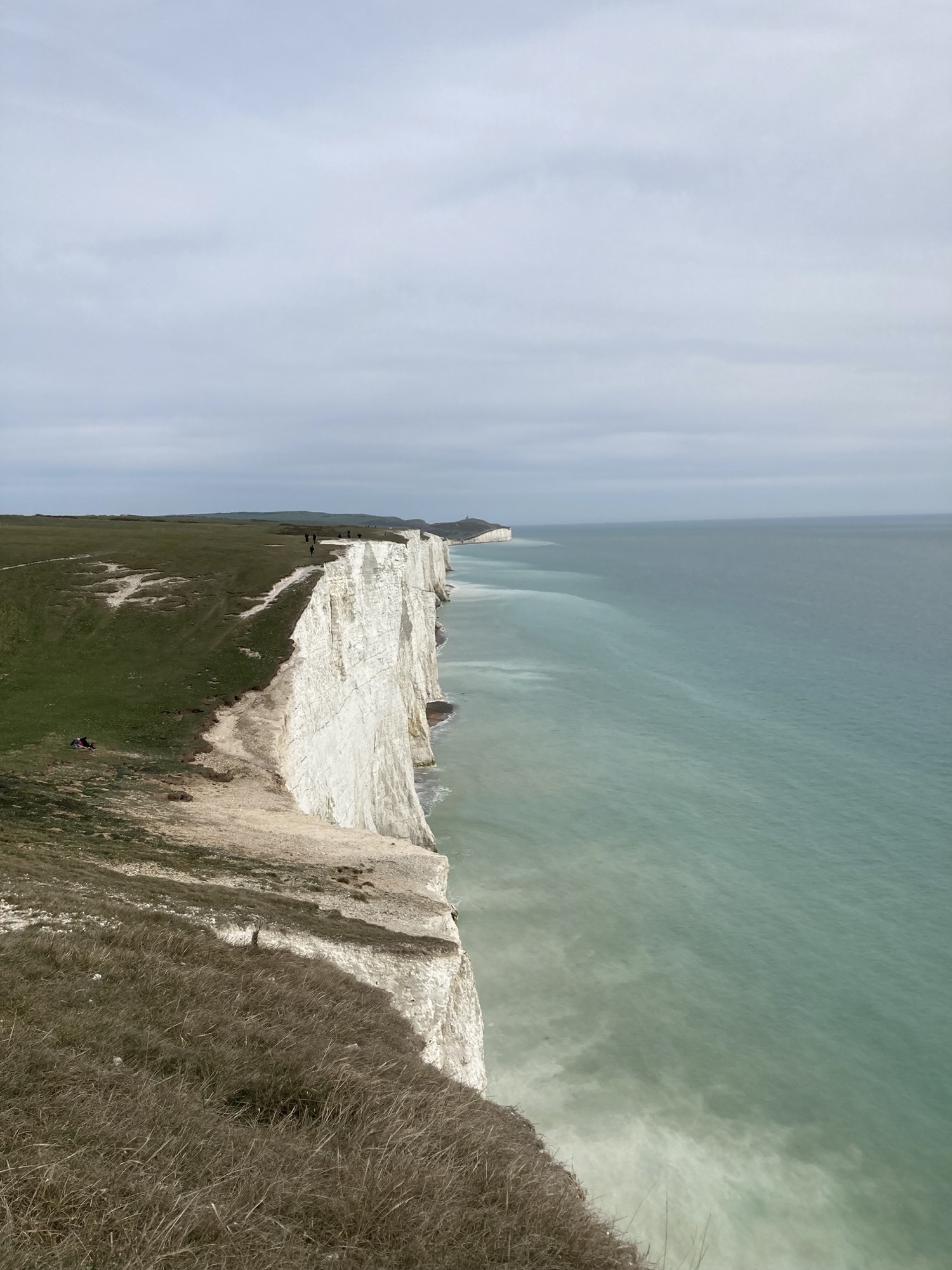 weiße Feldklippen an der südenglischen Küste, links Hügellandschaft, mittig Klippen, rechts Meer