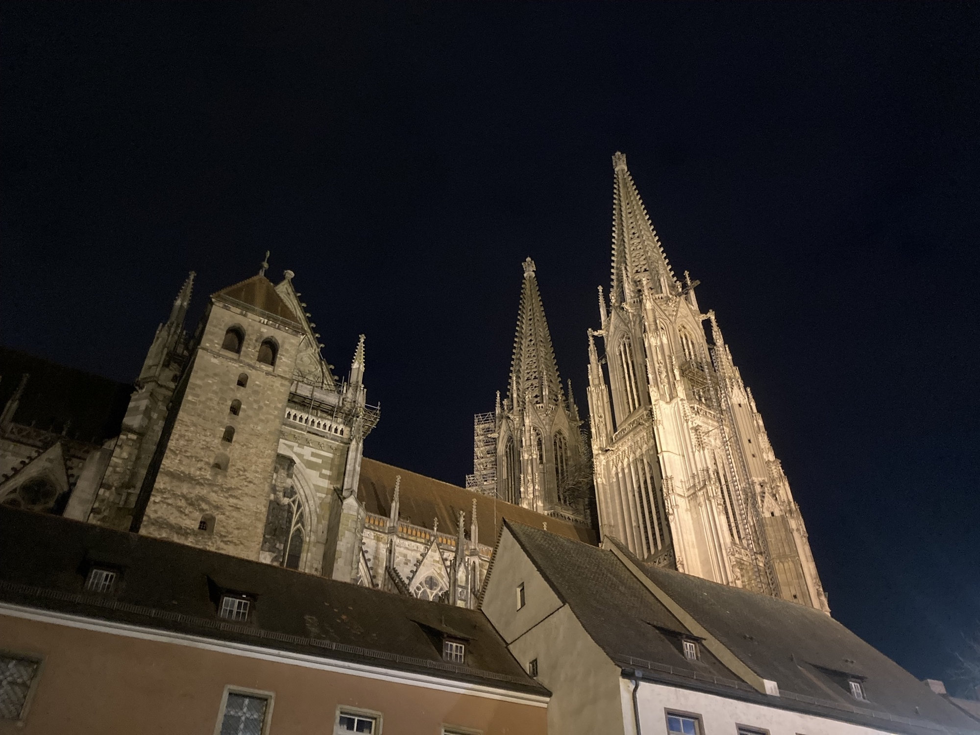 Seitenansicht des Regensburger Doms St. Peter, rechts ragen die beiden spitzen Türme des Hauptportals in die Luft, links davon das Mittelschiff und die Seitentürme