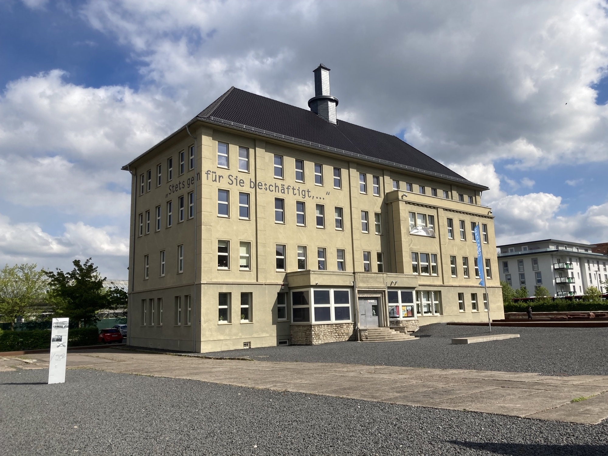 Haus auf dem Unternehmensgelände der früheren Firma „Topf und Söhne“, heute ein Erinnerungsort, zwischen dem dritten und vierten Stockwerk windet sich der Schriftzug „Stets gern für sie beschäftigt“ um die Ecke