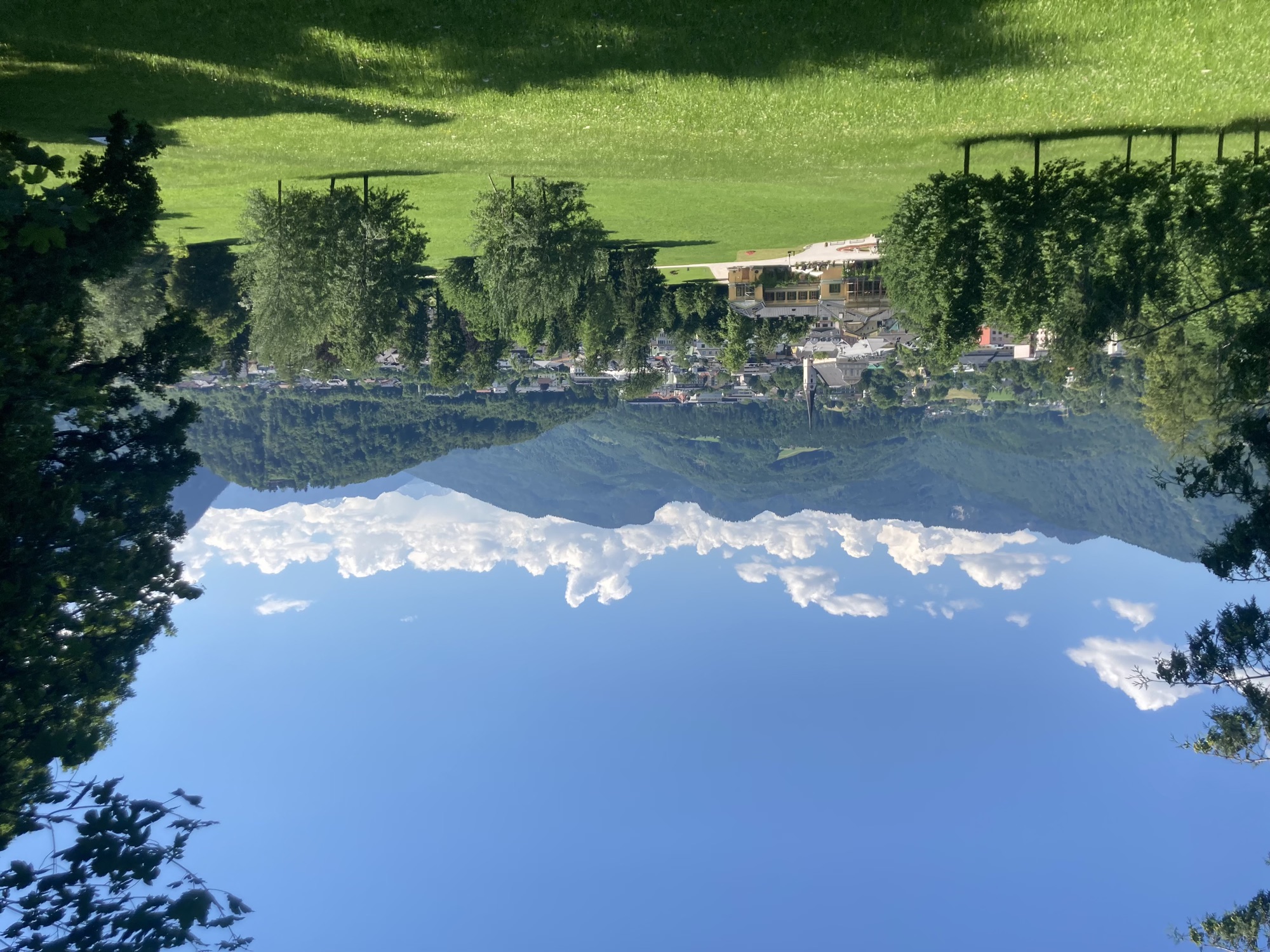 Ausblick auf die Stadt Bad Ischl, im Vordergrund grüne Wiese und Bäume, dahinter die Kaiservilla und der Kirchturm, der Himmel ist blau mit ein paar Wölkchen