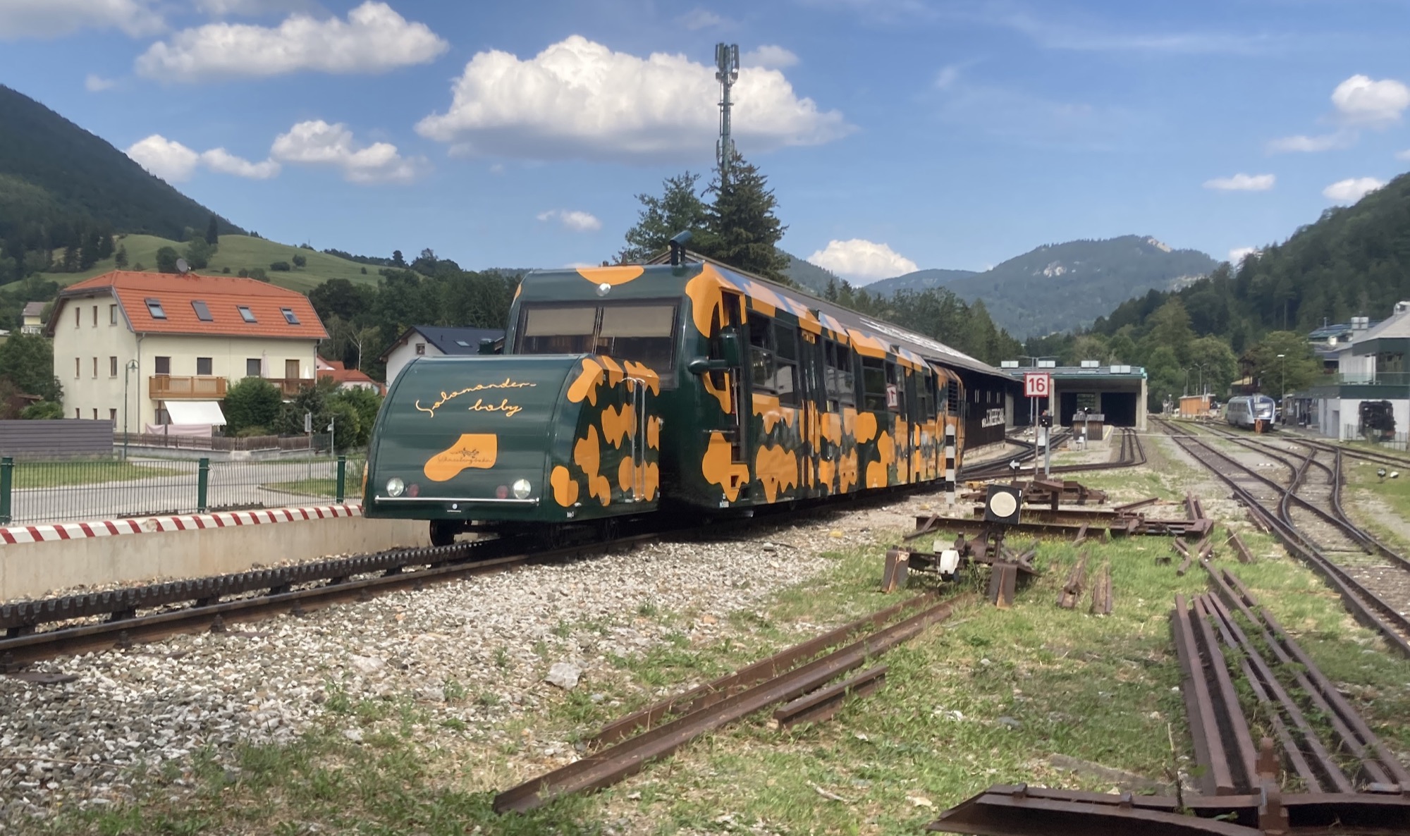 die Zahnradbahn auf den Schneeberg bei der Ausfahrt aus der Talstation, die Bahn ist grün mit gelben Flecken