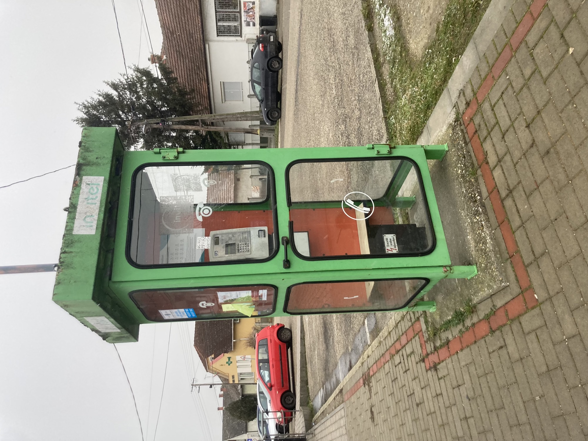 grüne Telefonzelle, die schon bessere Tage gesehen hat